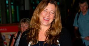 Nancy Hallam smiling confidently while standing outdoors, dressed professionally and radiating positivity