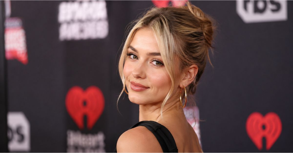 Billie Henry at a red carpet event with elegant style and a modern celebrity backdrop.