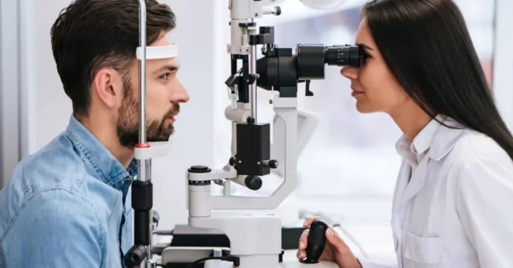 A patient undergoing an eye examination with a doctor using a slit lamp in a clinical setting.