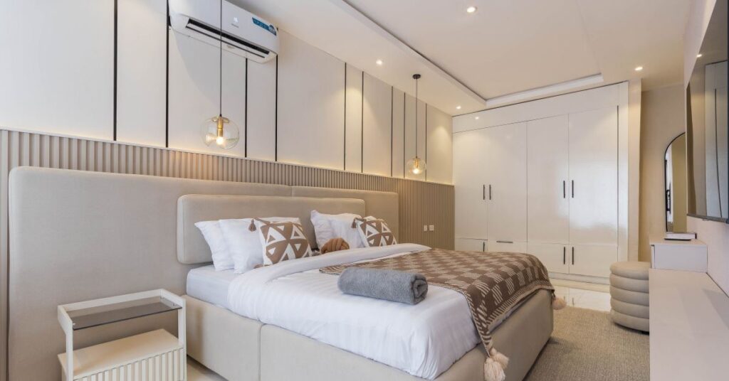 Modern luxury bedroom interior with a neatly made bed, soft lighting, and built-in wardrobes in a clean, minimalist design.
